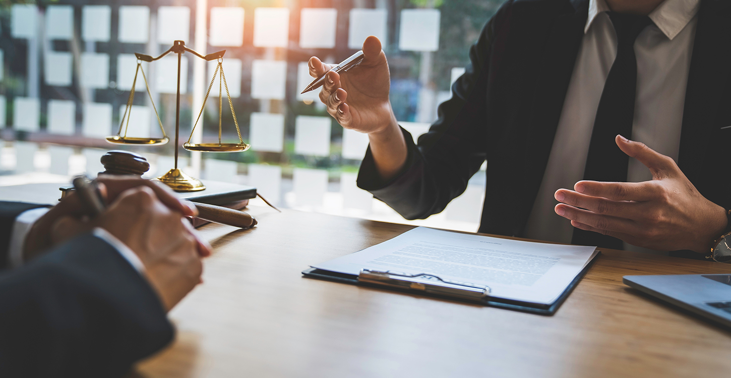 Two attorneys sitting at a table negotiating a contract.